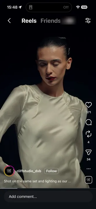 The original Instagram reel by cliffstudio_dxb: a model in a satin dress on a dark set.