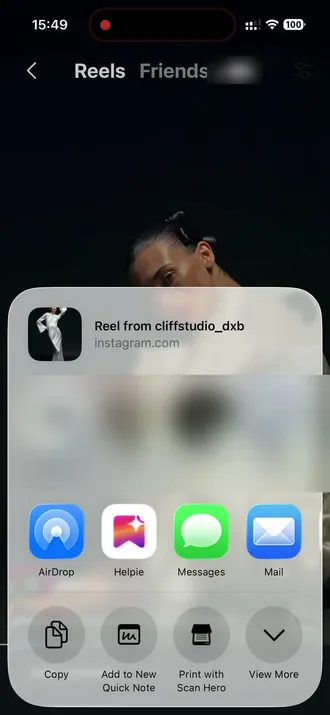 The iOS share sheet over the reel, with Helpie among the apps.